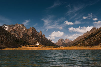 Scenic view of sea and mountains against sky