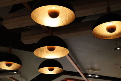 Low angle view of illuminated pendant lights hanging from ceiling