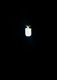 Low angle view of illuminated lamp against black background