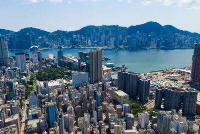 Aerial view of cityscape by river against sky