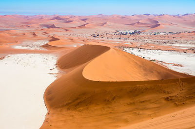 Sand dunes in desert against sky