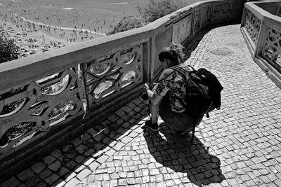 High angle view of woman photographing on footpath