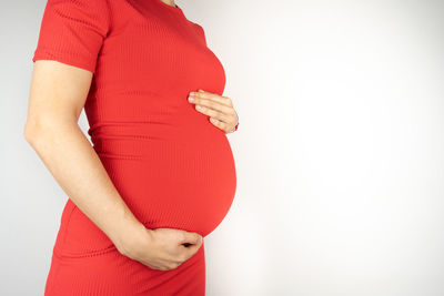 Midsection of woman standing against white background