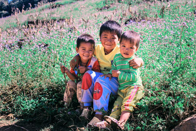 Portrait of happy siblings against plants