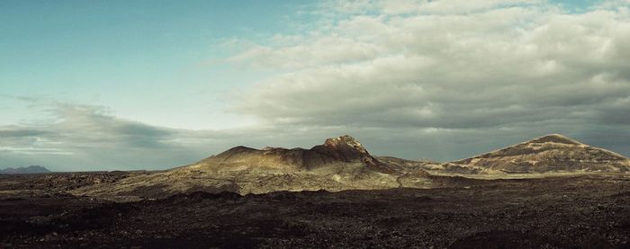 Scenic view of mountains against cloudy sky