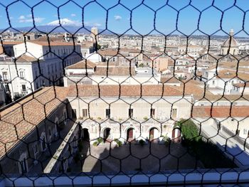 Rooftop view of catania from behind chain  fence