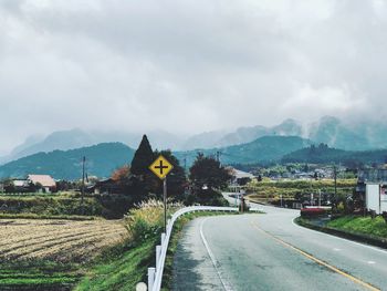 Road by city against sky