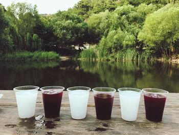 Drinks in glasses on pier by lake