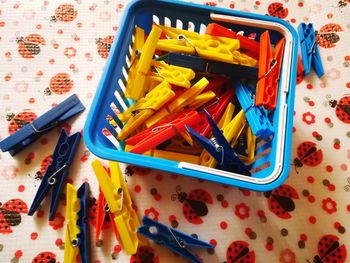 High angle view of colorful clothespins in bucket on table