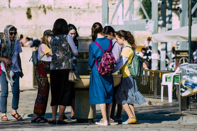 Rear view of people standing in city