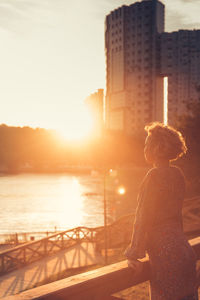 Woman standing at railing in city