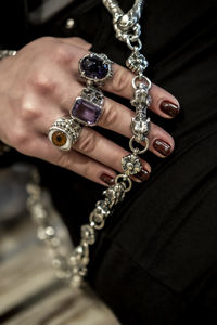 Cropped hand of woman holding pearl jewelry