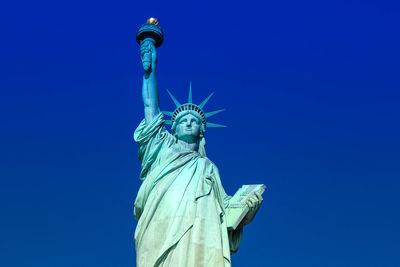 Low angle view of statue against blue sky