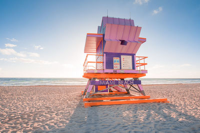 Lifeguard hut on beach against sky