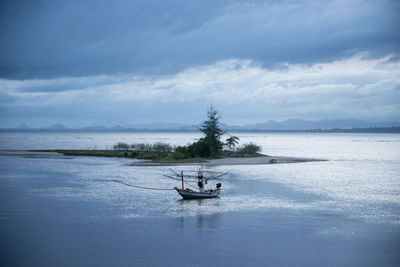 Man on boat in sea against sky