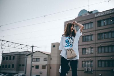 Portrait of woman standing against built structure