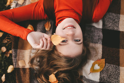 A pretty girl enjoys solitude drinks coffee walks in the autumn forest in nature in fall