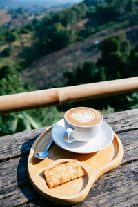 Close-up of coffee on table against landscape