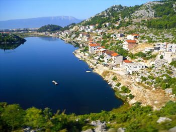 High angle view of townscape by river in city