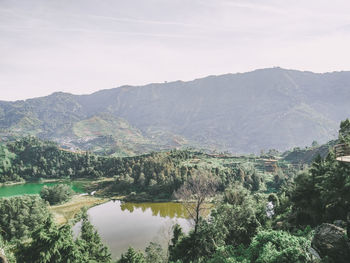 Scenic view of river and mountains against sky