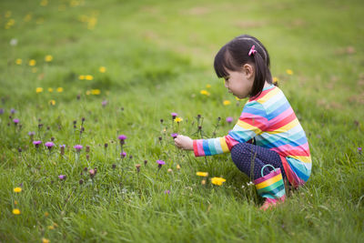 Side view of young  girl on grassy field