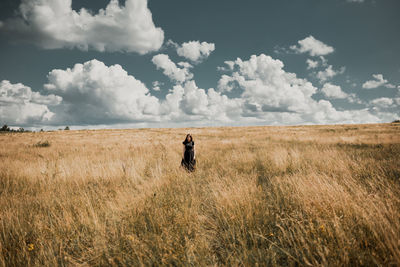 Woman standing on field against sky