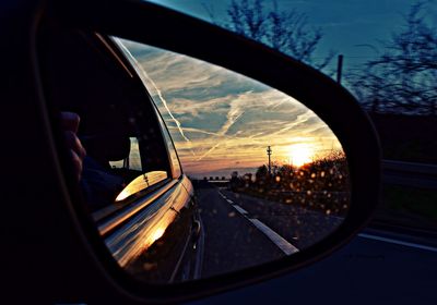 Cropped image of car on road at sunset