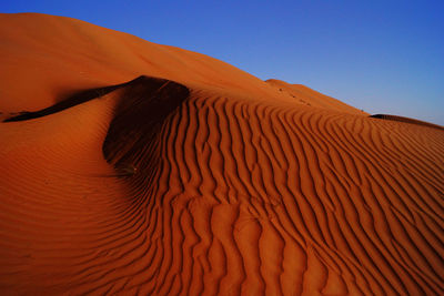 Scenic view of desert against blue sky