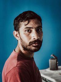 Portrait of young man against blue background
