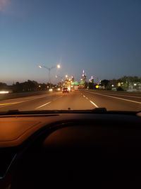 Illuminated city seen through car windshield