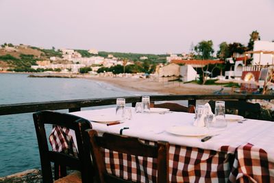 Chairs and tables at restaurant against clear sky