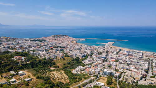 High angle view of townscape by sea against sky