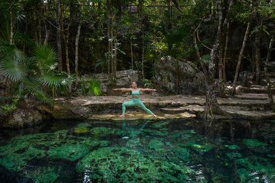 Woman doing a yoga pose in a cenote