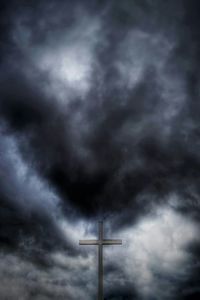 Low angle view of cross against dramatic sky