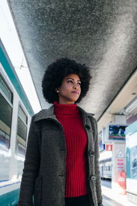 Portrait of woman standing at railroad station