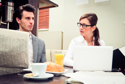 Young woman using laptop in restaurant