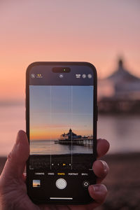 Cropped hand holding mobile phone