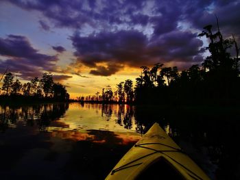 View of calm lake against cloudy sky during sunset