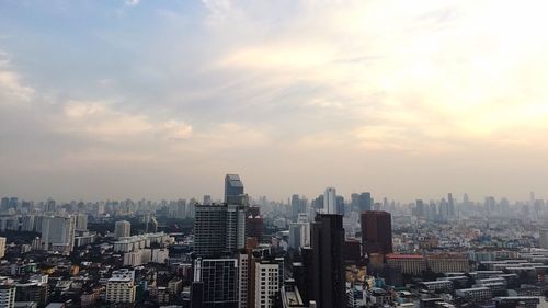 View of cityscape against cloudy sky