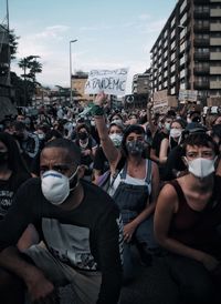 People on street in city against sky