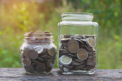 Close-up of coins in jars on table