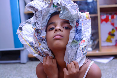 Close-up portrait of girl holding newspaper