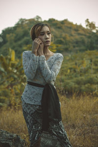 Young woman looking away on field