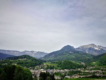 Scenic view of townscape and mountains against sky