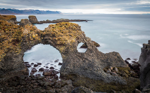 View of rock formation on beach against sky