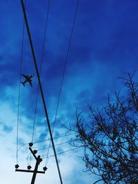 Low angle view of power lines against blue sky