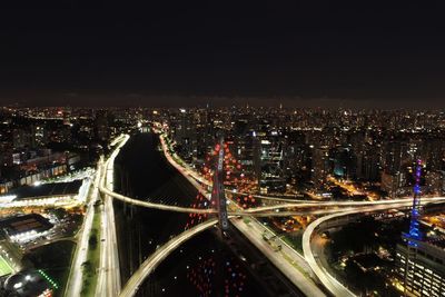 High angle view of illuminated bridge in city against sky at night