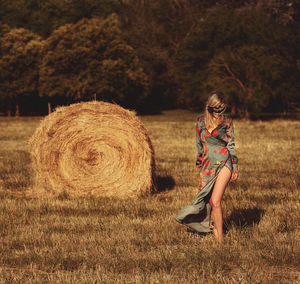 Full length portrait of young woman in field