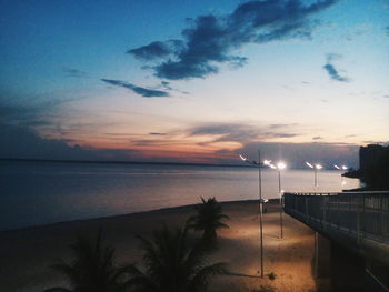 Swimming pool by sea against sky during sunset