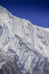 Scenic view of snowcapped mountains against clear sky